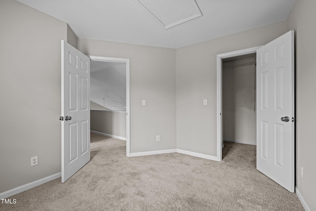 unfurnished bedroom featuring carpet, a spacious closet, and baseboards