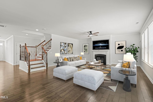 1013 Poppy Fields Ln, Wake Forest, NC 27587 - living room featuring a ceiling fan, dark wood-type flooring, a glass covered fireplace, stairs, and crown molding