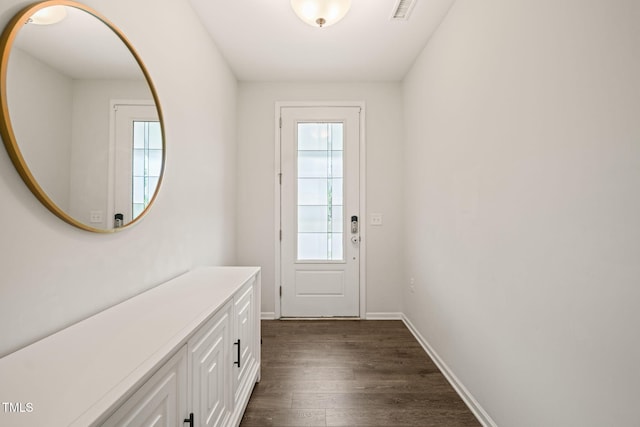 doorway to outside featuring dark wood-style flooring and baseboards