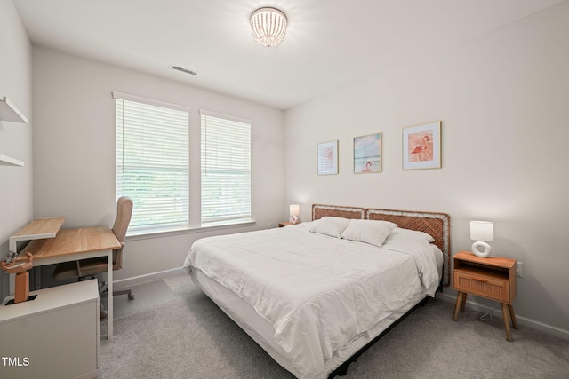 carpeted bedroom with baseboards and a desk
