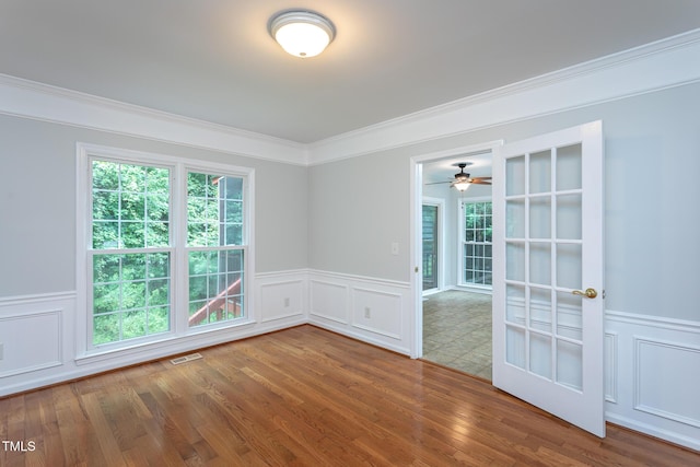 9305 Dominion Blvd, Raleigh, NC 27617 - spare room featuring a decorative wall, plenty of natural light, ornamental molding, wood finished floors, and ceiling fan