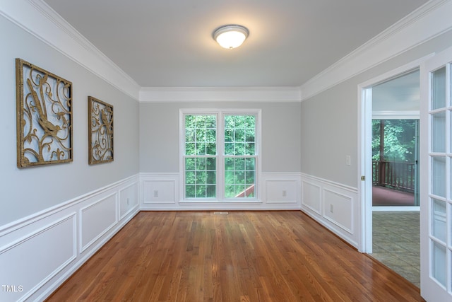 9305 Dominion Blvd, Raleigh, NC 27617 - empty room featuring ornamental molding, wood finished floors, a wainscoted wall, and a decorative wall
