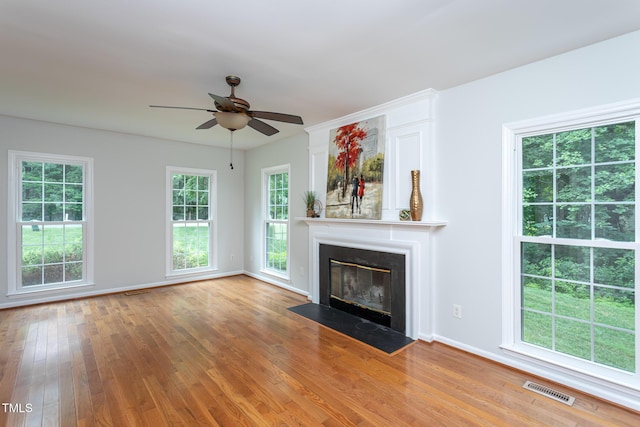 9305 Dominion Blvd, Raleigh, NC 27617 - unfurnished living room featuring healthy amount of natural light, light wood-type flooring, a ceiling fan, and a fireplace with flush hearth