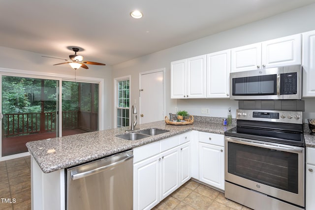 9305 Dominion Blvd, Raleigh, NC 27617 - kitchen featuring appliances with stainless steel finishes, a peninsula, white cabinets, a ceiling fan, and light stone counters