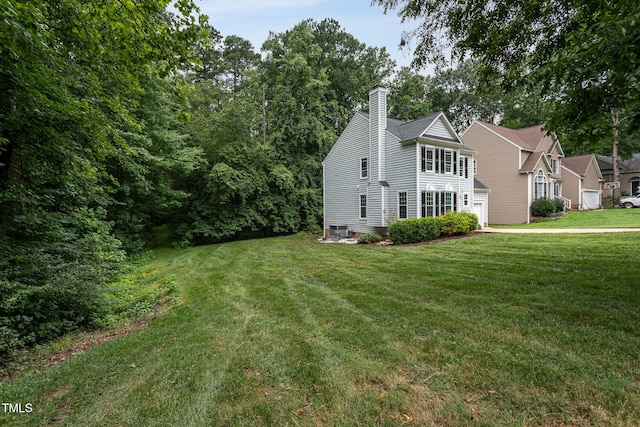 9305 Dominion Blvd, Raleigh, NC 27617 - view of home's exterior with a chimney, a yard, and an attached garage