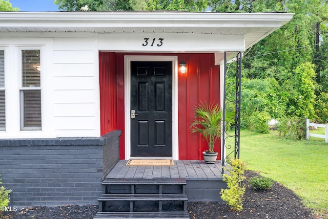 313 W Church St, Angier, NC 27501 - view of exterior entry with board and batten siding and a yard