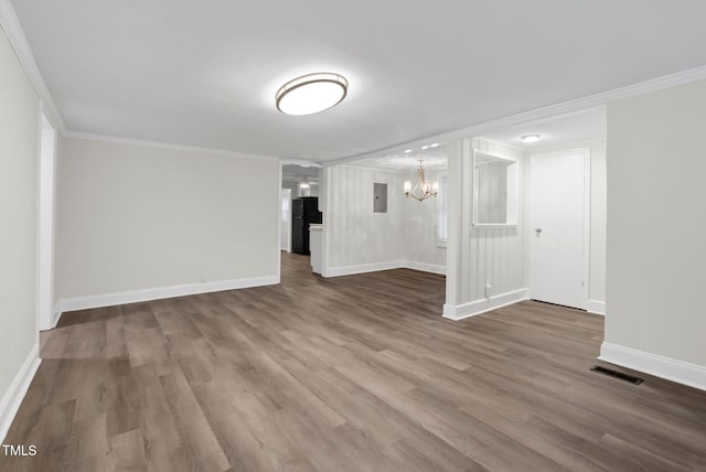 313 W Church St, Angier, NC 27501 - unfurnished room with a chandelier, ornamental molding, wood finished floors, baseboards, and electric panel