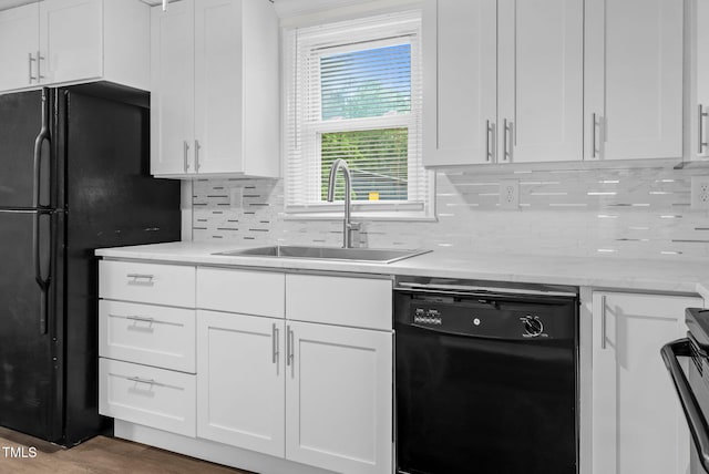 313 W Church St, Angier, NC 27501 - kitchen featuring black appliances, a sink, white cabinets, tasteful backsplash, and wood finished floors