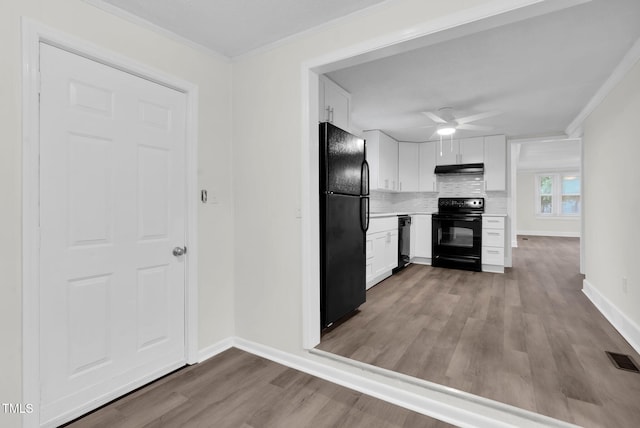 313 W Church St, Angier, NC 27501 - kitchen with black appliances, baseboards, wood finished floors, light countertops, and ornamental molding