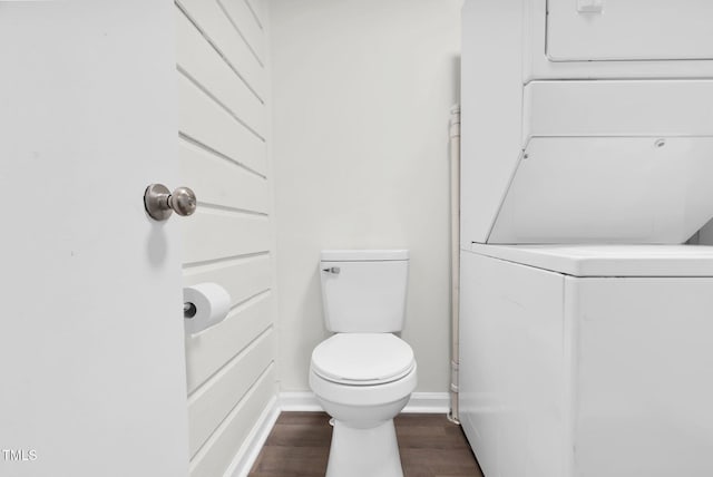 313 W Church St, Angier, NC 27501 - bathroom featuring stacked washer / dryer, wood finished floors, baseboards, and toilet