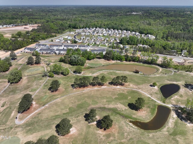 aerial view of property's location with a heavily wooded area, nearby suburban area, and a golf course