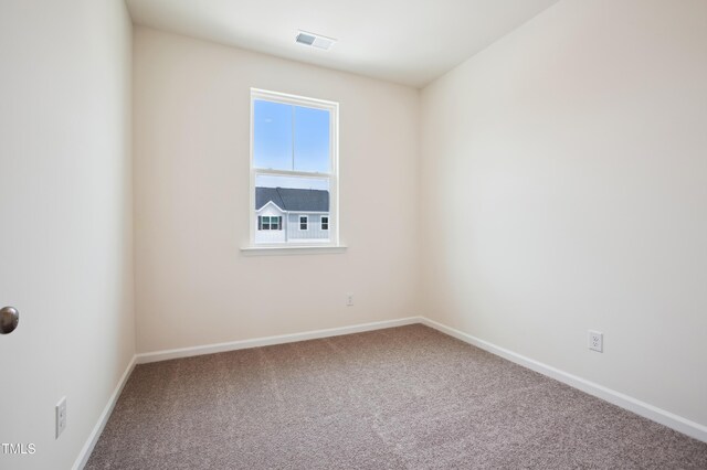 unfurnished room featuring carpet and baseboards