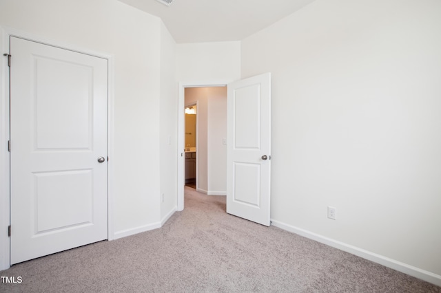 unfurnished bedroom featuring carpet flooring and baseboards