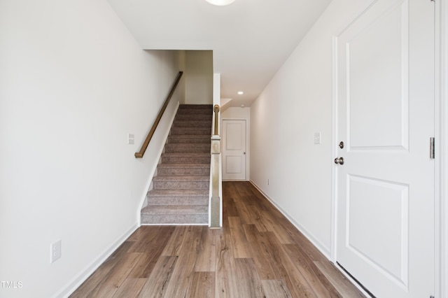 stairway featuring wood finished floors, baseboards, and recessed lighting