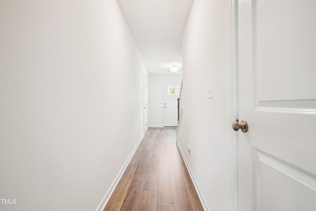 corridor with light wood-style flooring and baseboards