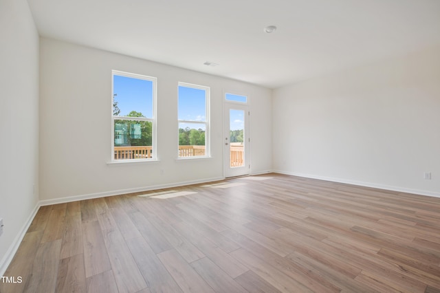 unfurnished room with light wood-style flooring and baseboards