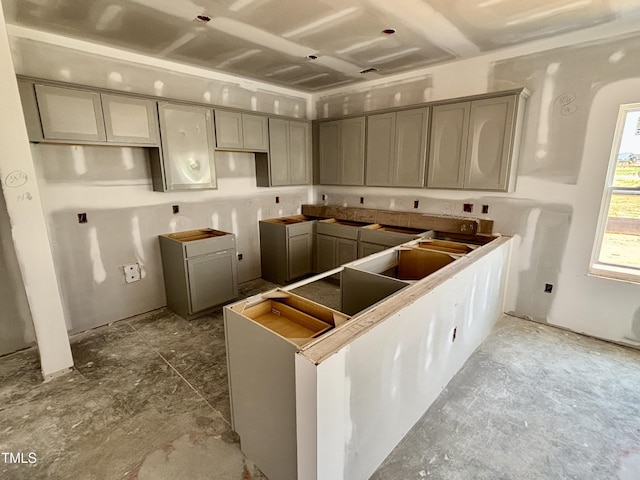kitchen with gray cabinets, a peninsula, and arched walkways