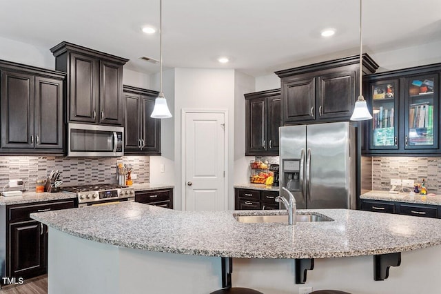 174 Walking Path Pl, Hillsborough, NC 27278 - kitchen featuring appliances with stainless steel finishes, a sink, backsplash, a breakfast bar, and hanging light fixtures
