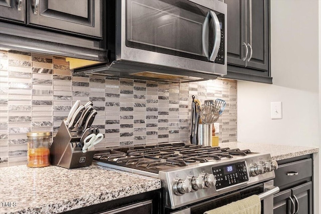 174 Walking Path Pl, Hillsborough, NC 27278 - kitchen with stainless steel appliances, backsplash, light stone counters, and dark cabinets