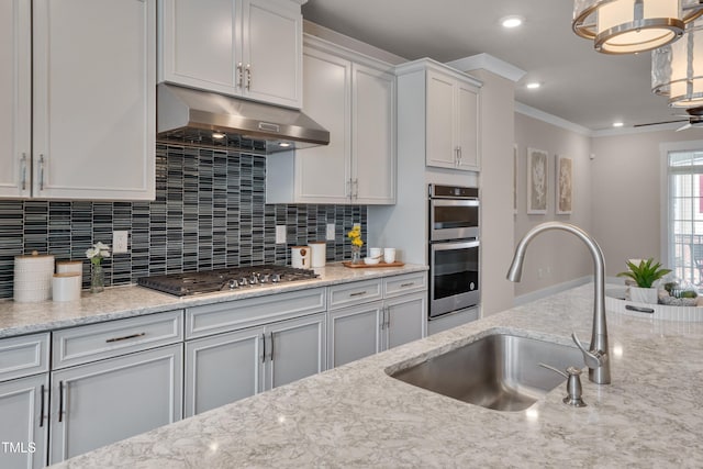 10330 Sablewood Dr Unit 104, Raleigh, NC 27617 - kitchen featuring under cabinet range hood, stainless steel appliances, decorative backsplash, crown molding, and light stone countertops