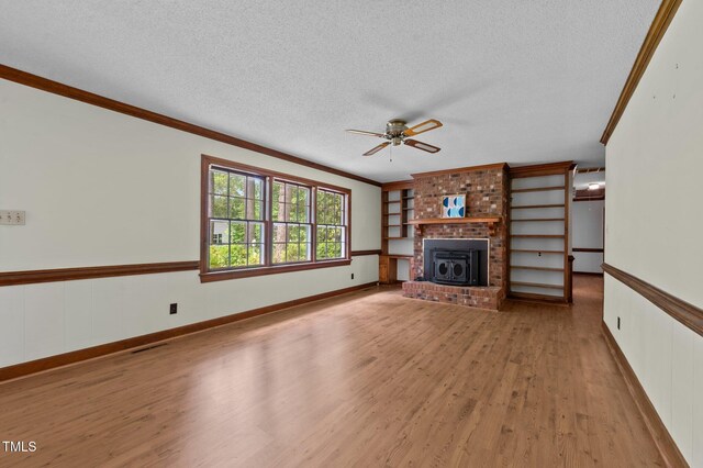 2610 N Main St, Tarboro, NC 27886 - unfurnished living room with a textured ceiling, crown molding, a ceiling fan, light wood finished floors, and a brick fireplace
