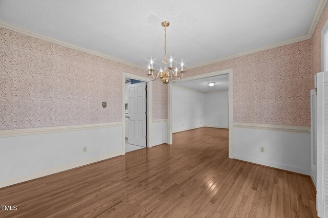 2610 N Main St, Tarboro, NC 27886 - spare room featuring crown molding, a chandelier, wallpapered walls, a wainscoted wall, and wood finished floors