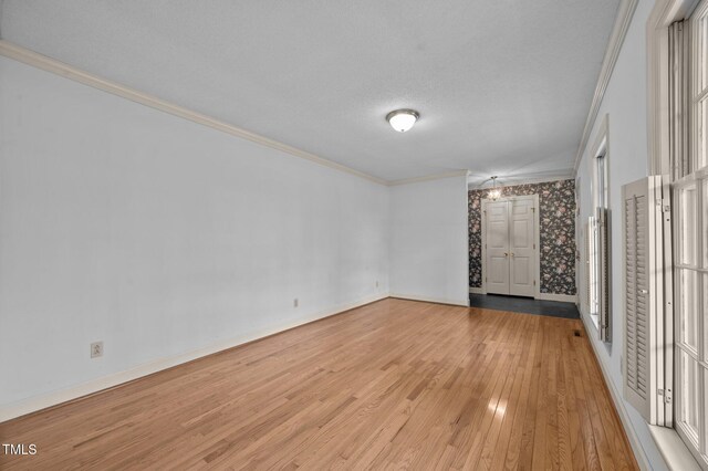 2610 N Main St, Tarboro, NC 27886 - empty room featuring light wood-style floors, crown molding, baseboards, and a textured ceiling