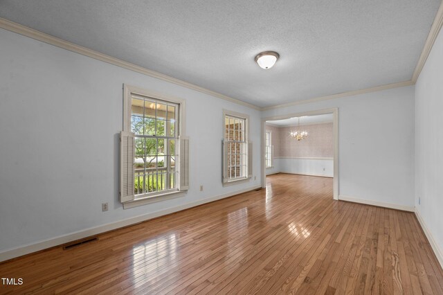 2610 N Main St, Tarboro, NC 27886 - empty room featuring a chandelier, crown molding, wood-type flooring, baseboards, and a textured ceiling