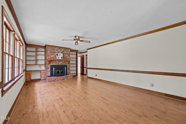 2610 N Main St, Tarboro, NC 27886 - unfurnished living room with ceiling fan, ornamental molding, light wood-style floors, a textured ceiling, and a fireplace