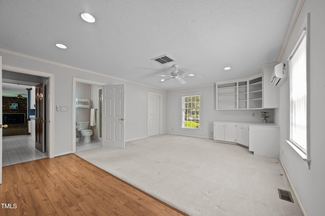 2610 N Main St, Tarboro, NC 27886 - unfurnished living room with a textured ceiling, baseboards, an AC wall unit, ornamental molding, and a ceiling fan