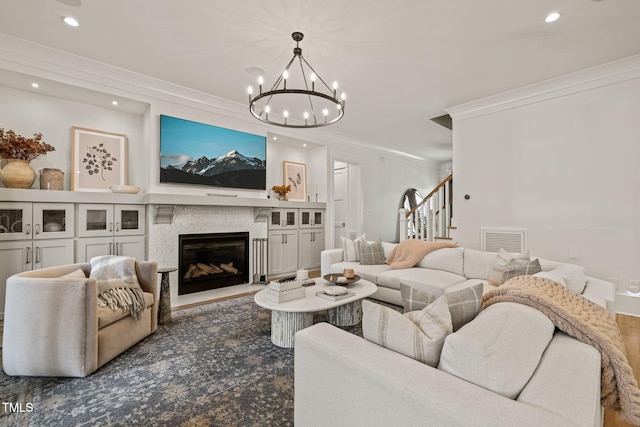 5308 Montclair Dr, Raleigh, NC 27609 - living area featuring recessed lighting, a chandelier, crown molding, stairs, and a glass covered fireplace