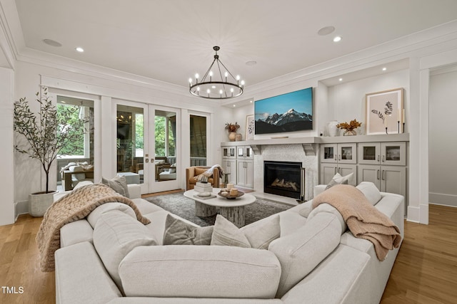 5308 Montclair Dr, Raleigh, NC 27609 - living room featuring crown molding, a chandelier, french doors, a premium fireplace, and recessed lighting