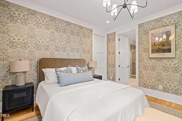 5308 Montclair Dr, Raleigh, NC 27609 - bedroom featuring wood finished floors, a chandelier, baseboards, wallpapered walls, and ensuite bathroom