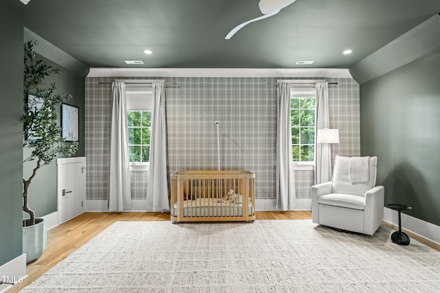 5308 Montclair Dr, Raleigh, NC 27609 - bedroom with wallpapered walls, baseboards, wood finished floors, recessed lighting, and a nursery area