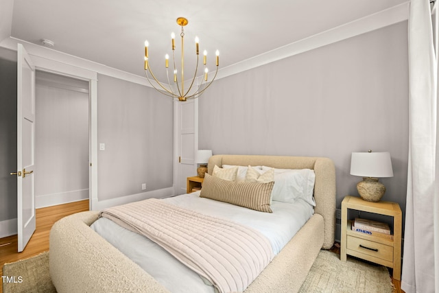 5308 Montclair Dr, Raleigh, NC 27609 - bedroom featuring a chandelier, wood finished floors, baseboards, and crown molding