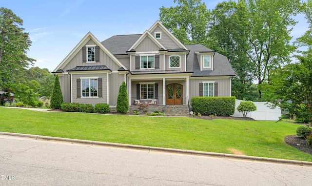 5308 Montclair Dr, Raleigh, NC 27609 - view of front facade featuring covered porch, board and batten siding, a standing seam roof, metal roof, and roof with shingles
