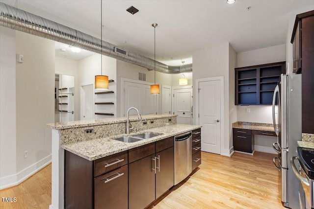 300 Finsbury St Unit 109, Durham, NC 27703 - kitchen featuring a sink, stainless steel appliances, light wood-style floors, dark brown cabinetry, and a center island with sink
