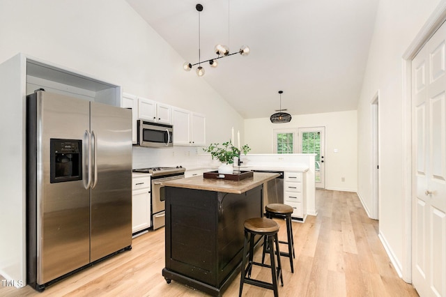 17 Crystal Oaks Ct, Durham, NC 27707 - kitchen with stainless steel appliances, high vaulted ceiling, white cabinetry, light wood finished floors, and a center island