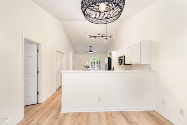 17 Crystal Oaks Ct, Durham, NC 27707 - kitchen featuring stainless steel appliances, white cabinets, a peninsula, light wood-style flooring, and high vaulted ceiling
