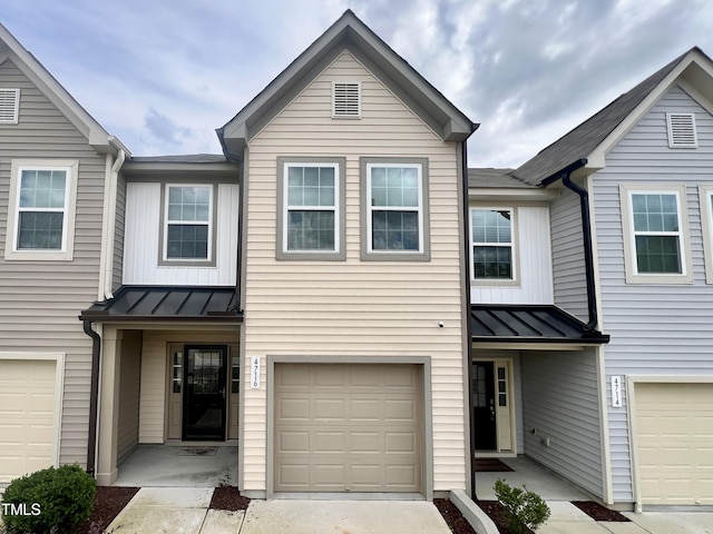 multi unit property with a standing seam roof, metal roof, and a garage
