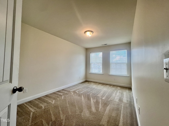 carpeted spare room with baseboards