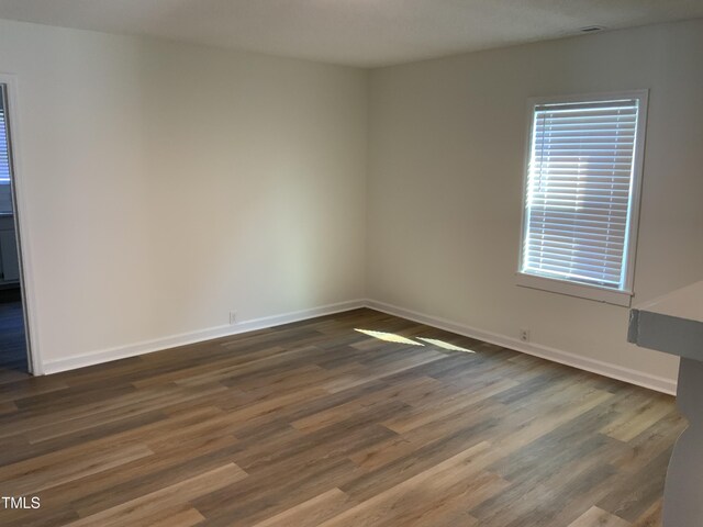 609 N Magnolia Ave, Dunn, NC 28334 - unfurnished room featuring baseboards and dark wood-style flooring