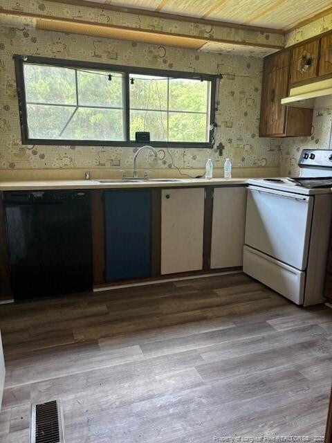5689 NE Maxwell Rd NW, Stedman, NC 28391 - kitchen with white electric range, dishwasher, under cabinet range hood, light countertops, and wood finished floors