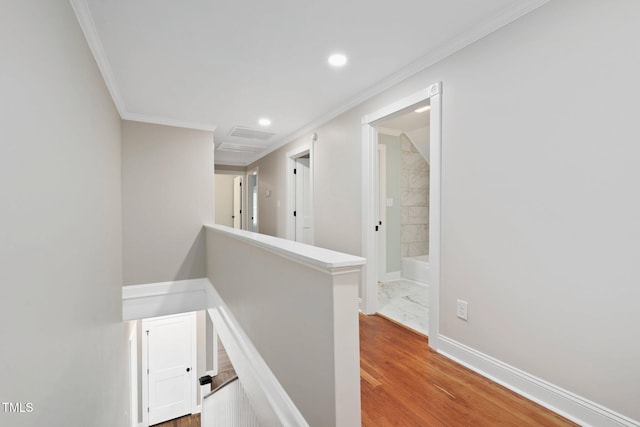 hall featuring an upstairs landing, ornamental molding, recessed lighting, baseboards, and wood finished floors