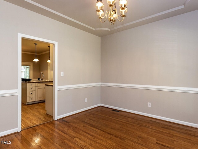 301 Monterey Ct, Benson, NC 27504 - spare room with wood finished floors, crown molding, a chandelier, baseboards, and a sink