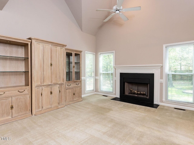 301 Monterey Ct, Benson, NC 27504 - unfurnished living room featuring light colored carpet, ceiling fan, high vaulted ceiling, healthy amount of natural light, and a fireplace with flush hearth