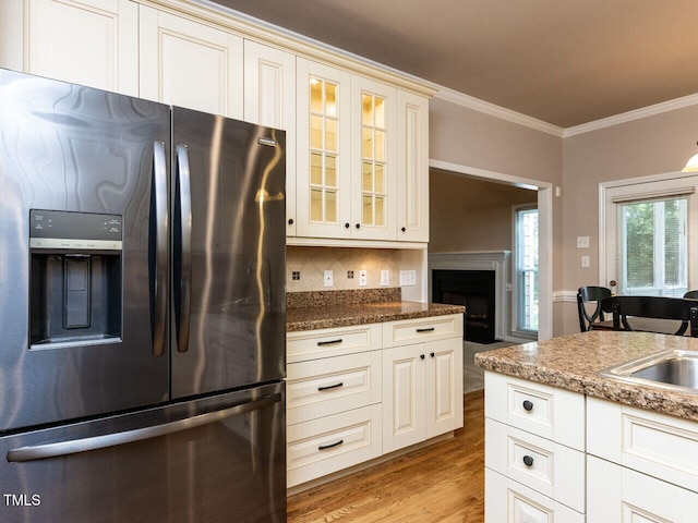 301 Monterey Ct, Benson, NC 27504 - kitchen featuring stainless steel fridge, glass insert cabinets, crown molding, light wood finished floors, and backsplash