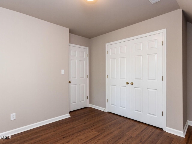 301 Monterey Ct, Benson, NC 27504 - unfurnished bedroom featuring baseboards, dark wood-type flooring, and a closet