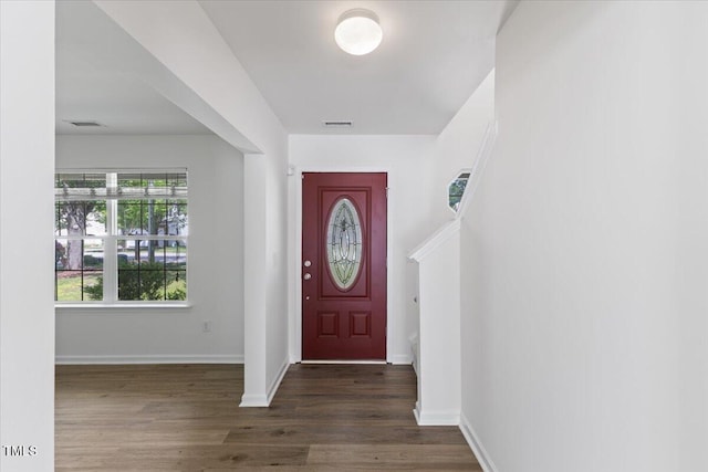 entrance foyer with dark wood-type flooring and baseboards