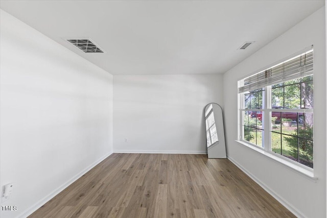 spare room featuring wood finished floors and baseboards